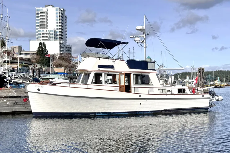  Yacht Photos Pics 1989 Grand Banks 42 yacht docked in marina, with cityscape background.
