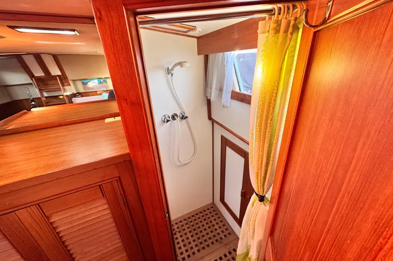  Yacht Photos Pics 1989 Grand Banks 42 interior shower area with wooden accents and curtain.