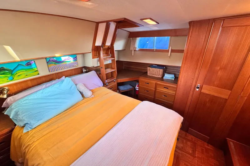  Yacht Photos Pics Luxurious 1989 Grand Banks 42 cabin interior with cozy bed and wooden furnishings.