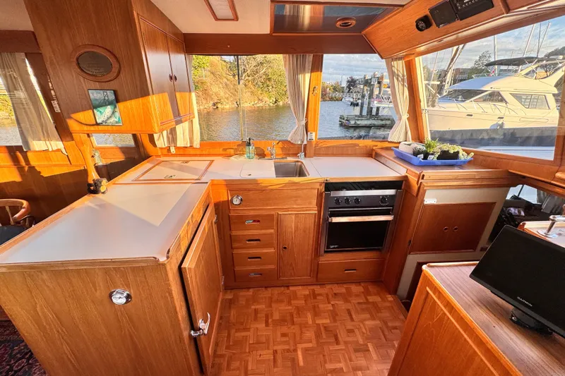  Yacht Photos Pics Interior of 1989 Grand Banks 42 yacht kitchen with wooden cabinetry and water view.