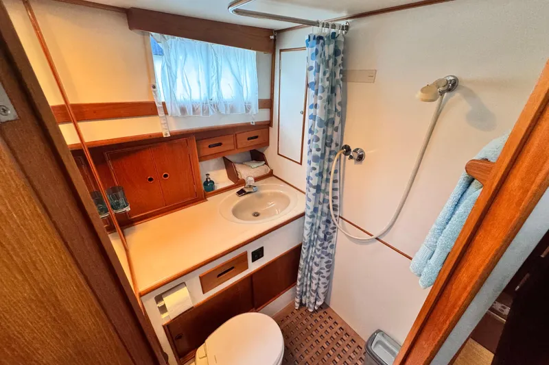  Yacht Photos Pics Bathroom of 1989 Grand Banks 42 yacht with shower, sink, and wooden cabinetry.