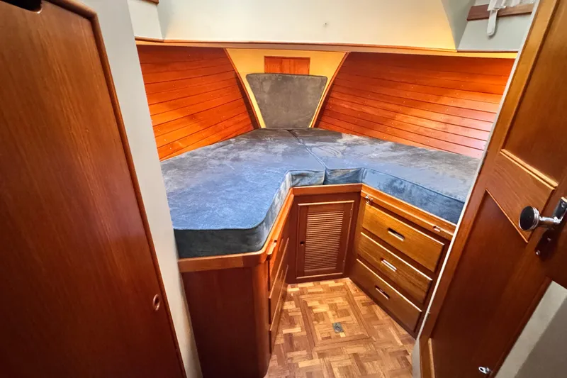  Yacht Photos Pics Cozy cabin interior of 1989 Grand Banks 42 with wooden paneling and storage drawers.