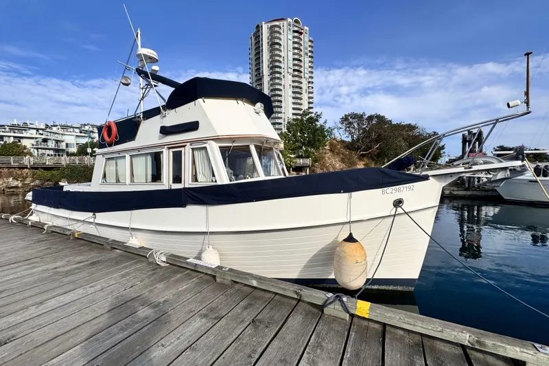  Yacht Photos Pics 1989 Grand Banks 42 yacht docked at marina with cityscape background.
