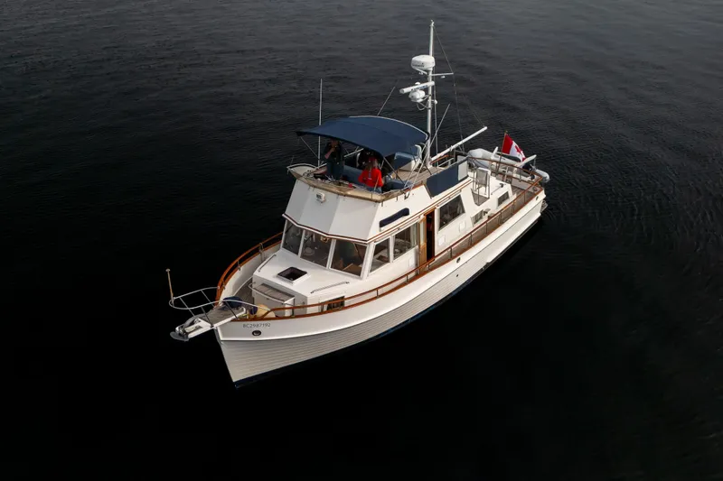  Yacht Photos Pics 1989 Grand Banks 42 yacht on calm water, featuring classic design and Canadian flag.