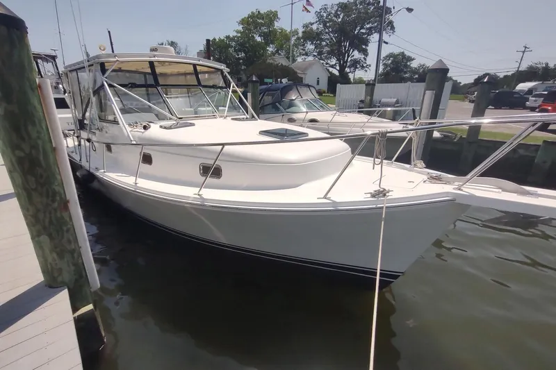 "rosebud" Yacht Photos Pics 2003 Mainship 34 PILOT boat docked at marina, featuring sleek white design and spacious deck.