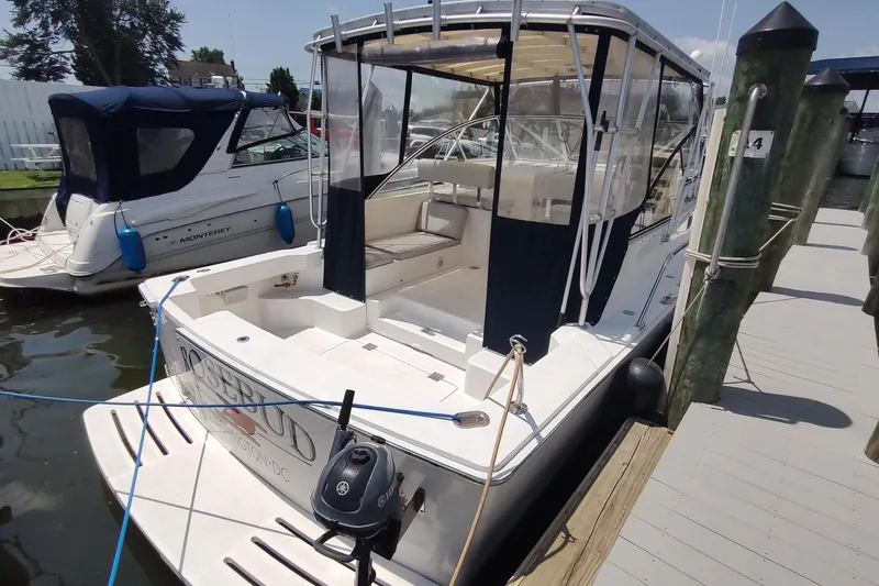 "rosebud" Yacht Photos Pics 2003 Mainship 34 PILOT docked, featuring a covered cockpit and adjacent boat.