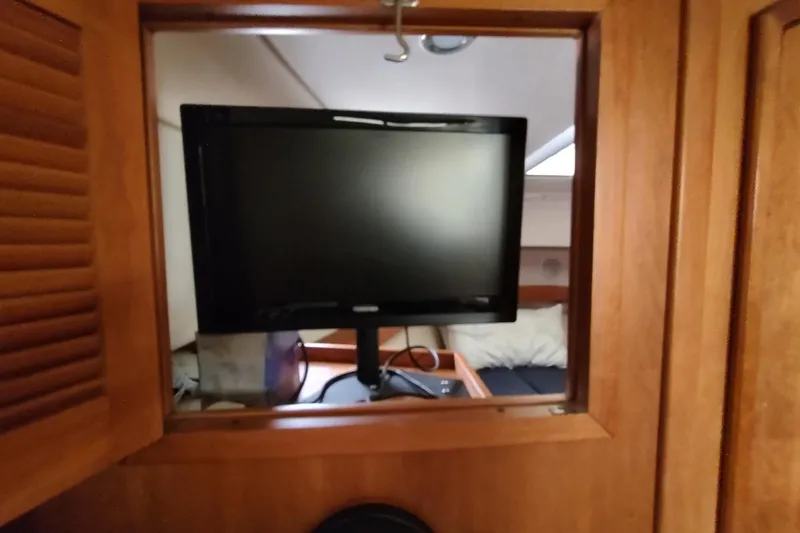 "rosebud" Yacht Photos Pics 2003 Mainship 34 PILOT interior with mounted TV and wooden cabinetry.