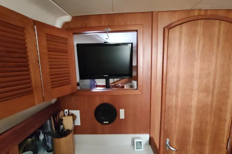 "rosebud" Yacht Photos Pics Interior of 2003 Mainship 34 PILOT with wooden cabinetry and mounted TV.