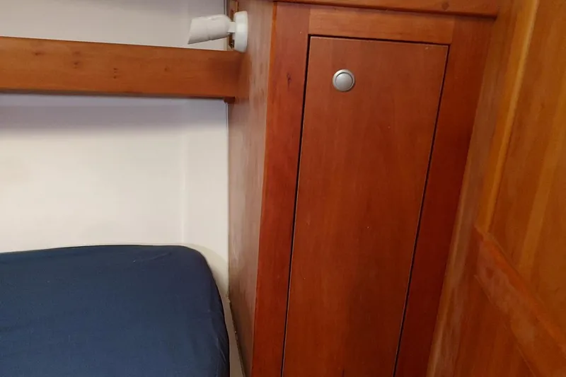 "rosebud" Yacht Photos Pics Wooden interior of 2003 Mainship 34 PILOT boat with blue cushion and cabinet.