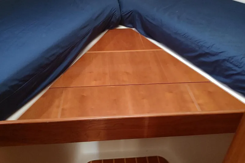 "rosebud" Yacht Photos Pics 2003 Mainship 34 PILOT cabin interior with blue bedding and wooden accents.