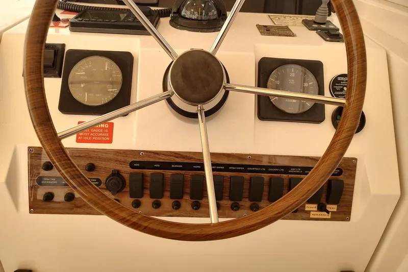 "rosebud" Yacht Photos Pics Steering wheel and dashboard of 2003 Mainship 34 PILOT boat, featuring gauges and controls.