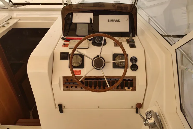 "rosebud" Yacht Photos Pics 2003 Mainship 34 PILOT helm with steering wheel, gauges, and navigation equipment.