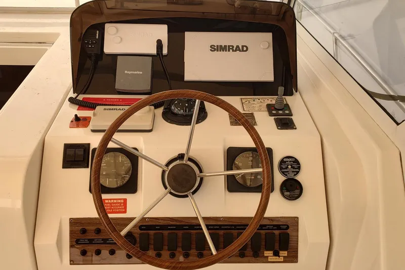 "rosebud" Yacht Photos Pics 2003 Mainship 34 PILOT helm with Simrad navigation and wooden steering wheel.
