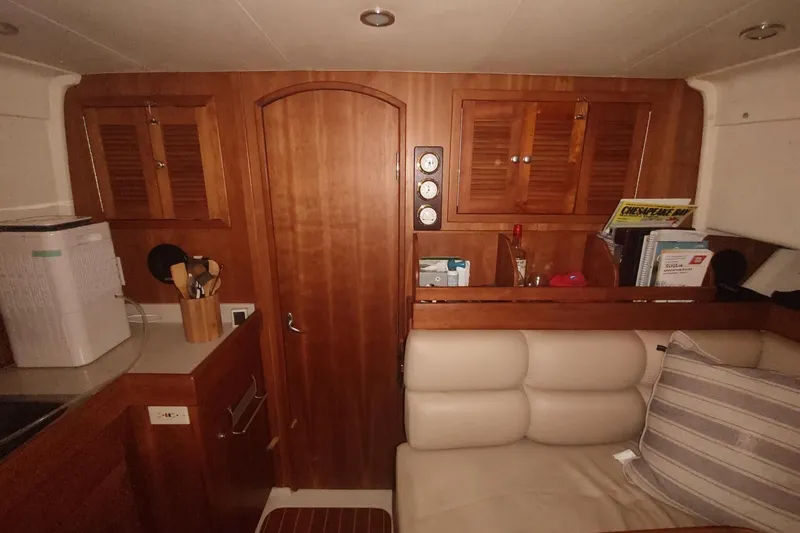 "rosebud" Yacht Photos Pics Interior of 2003 Mainship 34 PILOT with wooden cabinetry and cozy seating area.
