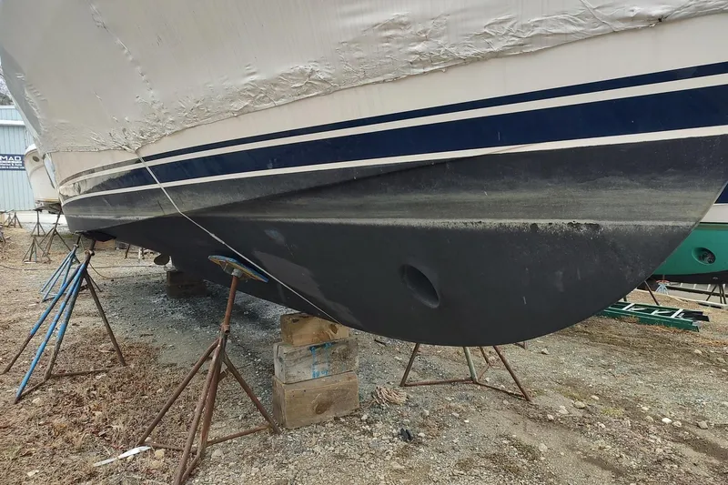 "rosebud" Yacht Photos Pics 2003 Mainship 34 PILOT boat on stands, partially covered, showing hull details.