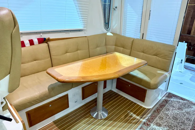 La Dolce Vita Yacht Photos Pics 2011 Back Cove 37 interior with beige seating, wooden table, and striped flooring.