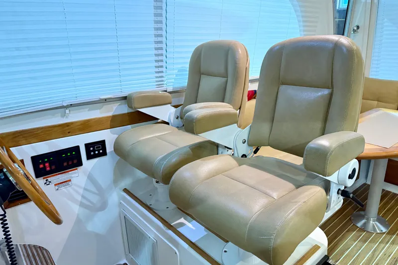 La Dolce Vita Yacht Photos Pics Helm seating area of 2011 Back Cove 37 boat with beige leather chairs.