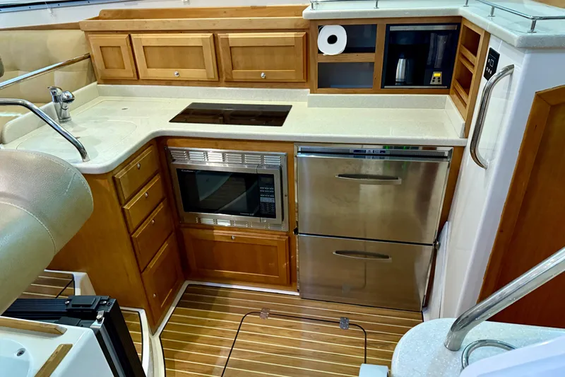 La Dolce Vita Yacht Photos Pics Luxurious 2011 Back Cove 37 yacht kitchen with modern appliances and wooden cabinetry.