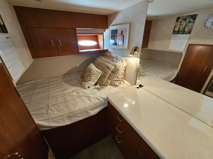 Early Bird Yacht Photos Pics Cozy cabin interior of 1998 Ocean Yachts 40, featuring a bed, pillows, and wooden cabinetry.