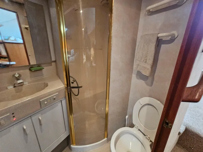 Early Bird Yacht Photos Pics Bathroom interior of a 1998 Ocean Yachts 40, featuring shower, sink, and toilet.