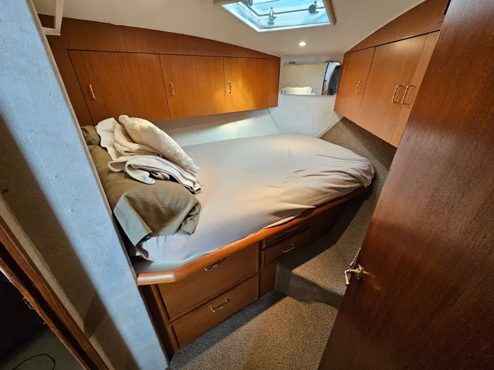 Early Bird Yacht Photos Pics Cozy cabin interior of a 1998 Ocean Yachts 40, featuring a comfortable bed and wooden cabinetry.