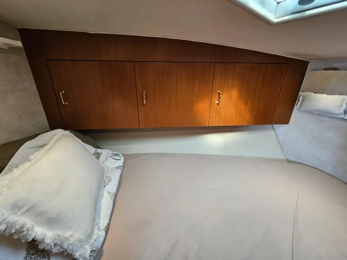 Early Bird Yacht Photos Pics 1998 Ocean Yachts 40 interior cabin with wooden cabinets and a cozy bed.