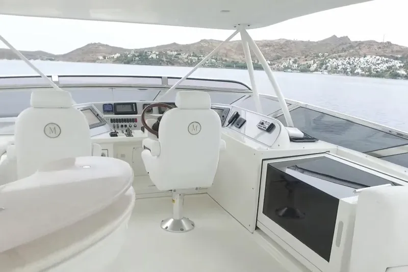  Yacht Photos Pics Helm of 2008 Marquis 690 Fly yacht with modern controls and scenic water view.