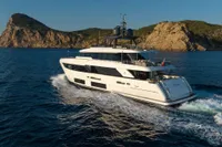 Luxurious 2020 Custom Line Navetta 33 yacht cruising near rocky coastline.