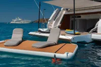 Luxury yacht Navetta 33 with floating deck and loungers on serene blue water.