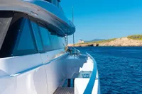 Luxury yacht Custom Line Navetta 33 cruising near rocky coastline, 2020 model.