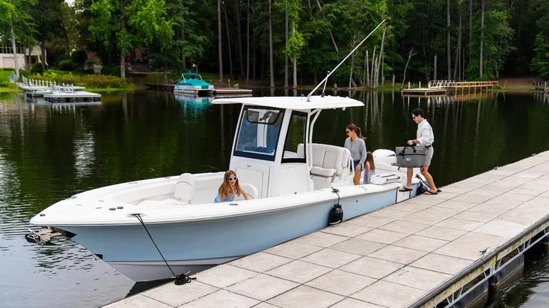  Yacht Photos Pics 2025 Sea Hunt Ultra 265 SE boat docked on a serene lake with people onboard.