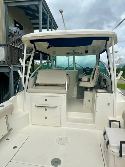 Thomfoolery II Yacht Photos Pics 2016 Boston Whaler 315 Conquest boat interior with seating and helm, under cloudy sky.