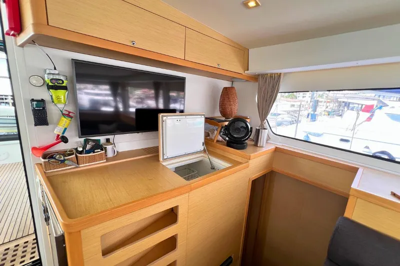 Mocean Yacht Photos Pics Interior of 2017 Lagoon 42 yacht with TV, storage, and window view.