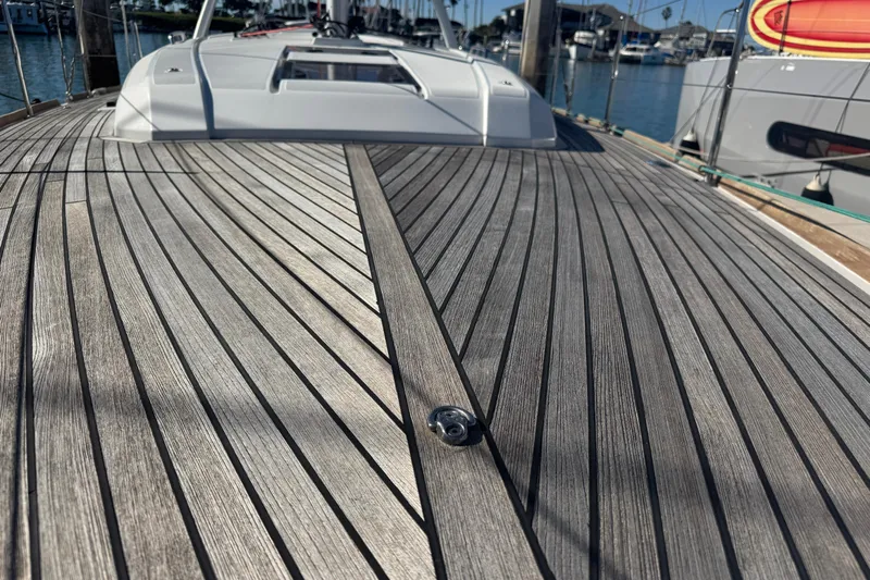  Yacht Photos Pics Deck of 2023 Beneteau Oceanis 38.1 sailboat with sleek wooden finish in marina.