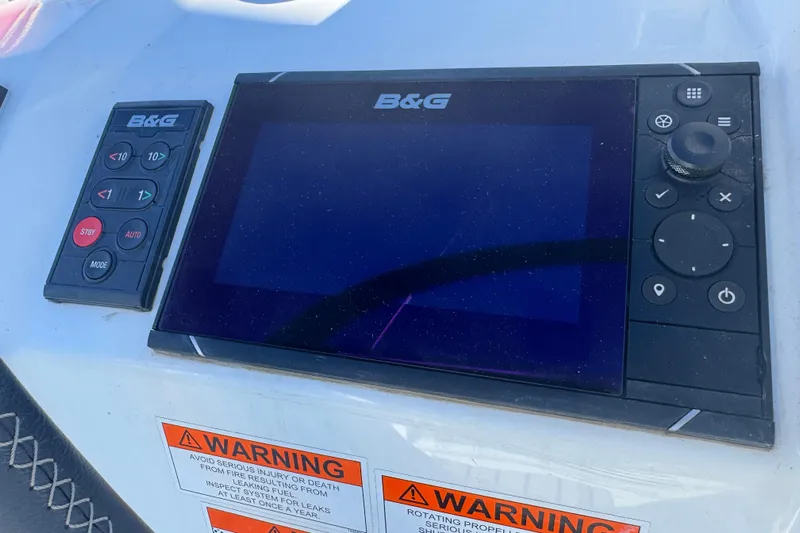  Yacht Photos Pics B&G navigation system on 2023 Beneteau Oceanis 38.1 yacht dashboard with warning labels.