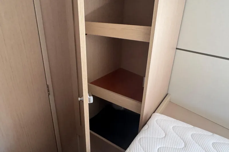  Yacht Photos Pics Interior storage cabinet on 2023 Beneteau Oceanis 38.1 yacht, featuring wooden shelves.