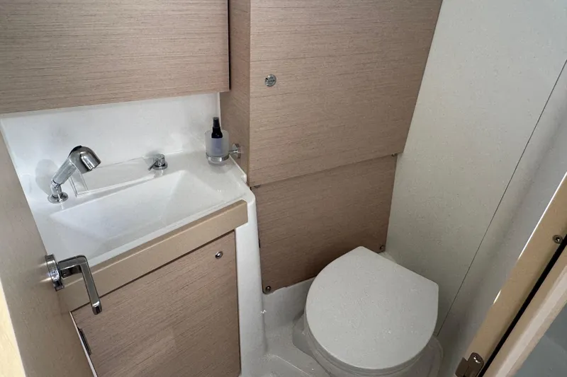  Yacht Photos Pics 2023 Beneteau Oceanis 38.1 yacht bathroom with sink and toilet.
