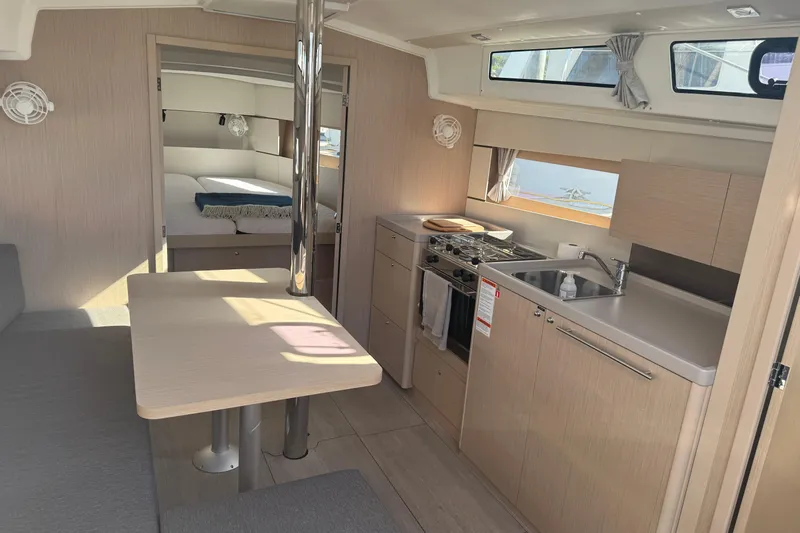  Yacht Photos Pics Modern interior of 2023 Beneteau Oceanis 38.1 yacht with kitchen and dining area.