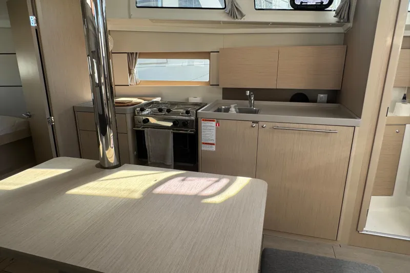  Yacht Photos Pics Interior of 2023 Beneteau Oceanis 38.1 yacht, featuring modern kitchen and dining area.