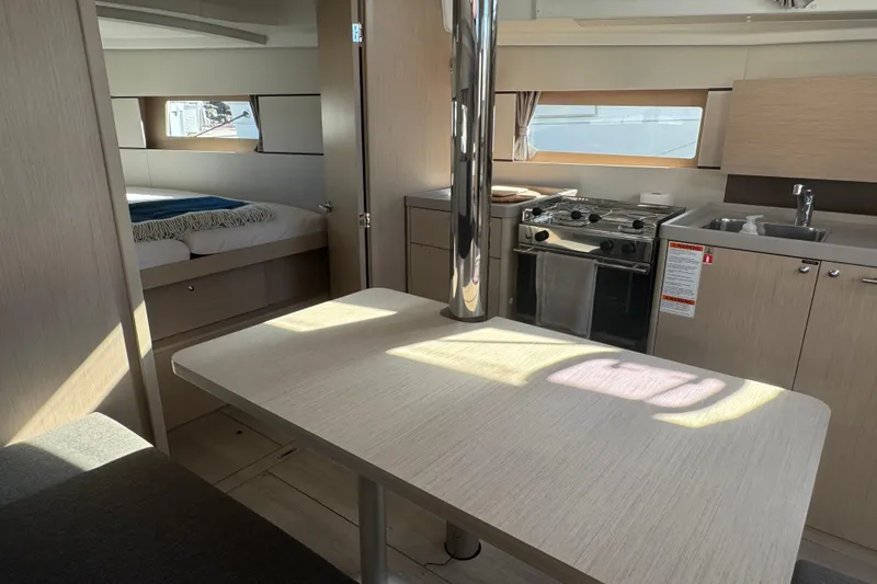  Yacht Photos Pics Interior of 2023 Beneteau Oceanis 38.1 yacht, featuring kitchen, dining area, and bedroom.