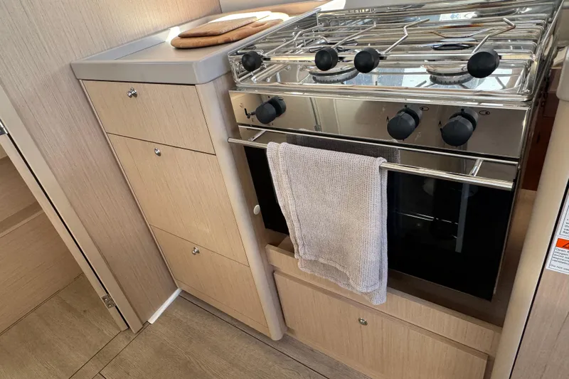 Yacht Photos Pics Modern kitchen in 2023 Beneteau Oceanis 38.1 yacht with stove and cabinetry.