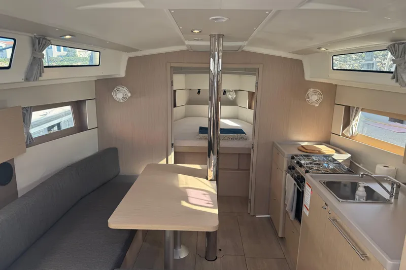  Yacht Photos Pics Interior of 2023 Beneteau Oceanis 38.1 yacht, featuring modern kitchen and cozy seating area.
