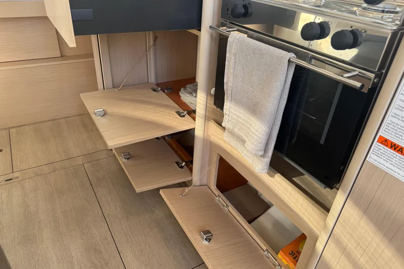  Yacht Photos Pics 2023 Beneteau Oceanis 38.1 yacht kitchen with open cabinets and oven.