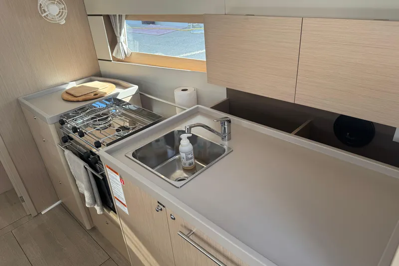  Yacht Photos Pics Modern kitchen in 2023 Beneteau Oceanis 38.1 yacht with stove and sink.