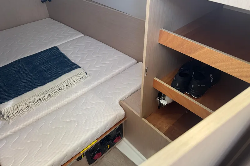 Yacht Photos Pics Cozy cabin interior of 2023 Beneteau Oceanis 38.1 with bed and storage shelves.