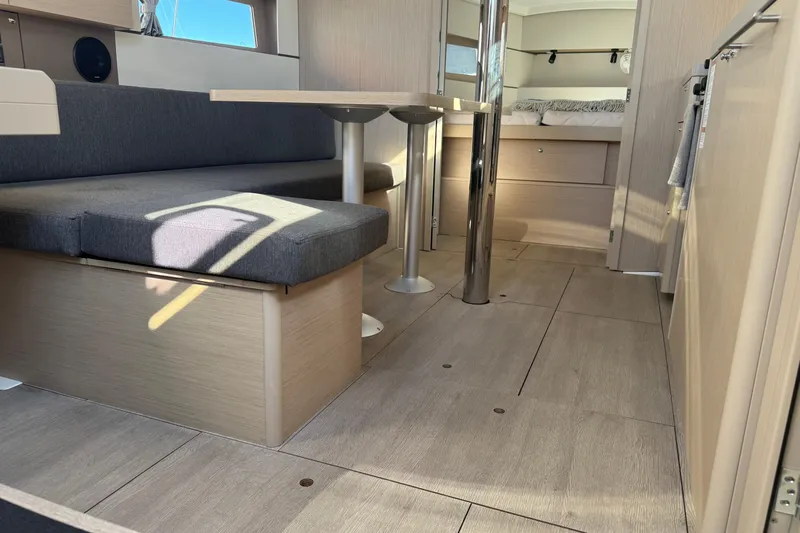  Yacht Photos Pics Modern interior of 2023 Beneteau Oceanis 38.1 yacht with sleek seating and dining area.