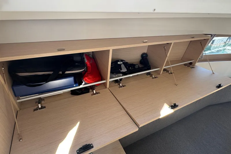  Yacht Photos Pics Storage compartments inside 2023 Beneteau Oceanis 38.1 yacht, featuring organized shelves and gear.