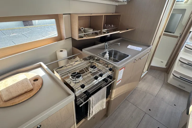  Yacht Photos Pics Modern kitchen in 2023 Beneteau Oceanis 38.1 yacht with stove, sink, and storage.