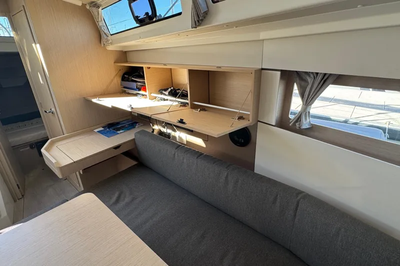  Yacht Photos Pics Interior of 2023 Beneteau Oceanis 38.1 yacht, featuring modern wood cabinetry and seating.