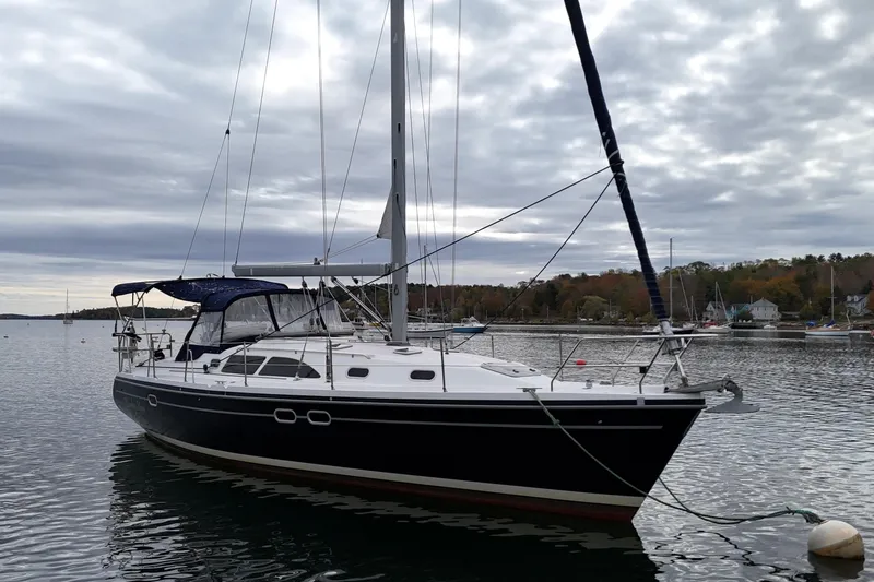 Rendez-vous Yacht Photos Pics 2003 Catalina 387 sailboat anchored on a calm lake under cloudy skies.